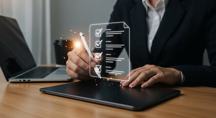 Person in suit using digital pen on tablet with checklist overlay near laptop on wooden desk top