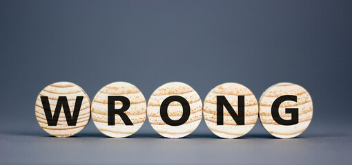 Wrong symbol. Concept word Wrong on beautiful wooden circles. Beautiful grey table grey background....