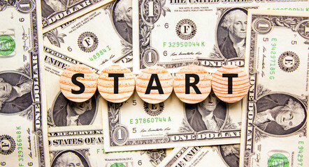 Start symbol. Concept word Start on beautiful wooden circles. Beautiful dollar bills. Beautiful...