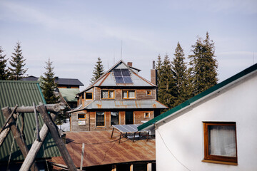 Old wooden house with solar panels on the roof. Saving electricity.