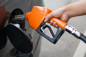Refuel your car at a gas station using the orange and yellow fuel dispenser.