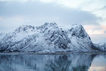 Breathtaking SnowCovered Mountains Reflecting Beautifully in the Calm Water at Dusk