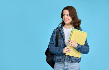Pretty student girl holding notebooks and looking away, isolated on blue background.