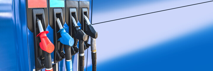 Close-up of fuel pistols at a gas station. Long banner.