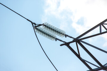 High voltage tower with electrical voltage wires isolates close-up against the background of...