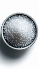 Overhead shot of granulated sugar in a small bowl, isolated on white.
