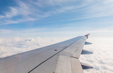 Fototapeta premium View from the airplane window at a beautiful cloudy sky and the airplane wing