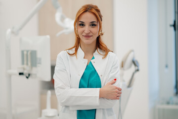 Dentist smiling with crossed arms in dental clinic