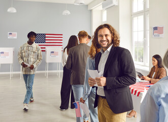 Young happy american voter standing in a queue at vote center and looking cheerful at the camera...