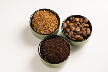 Different types of coffee. Ground coffee, instant coffee and roasted coffee beans in small bowls