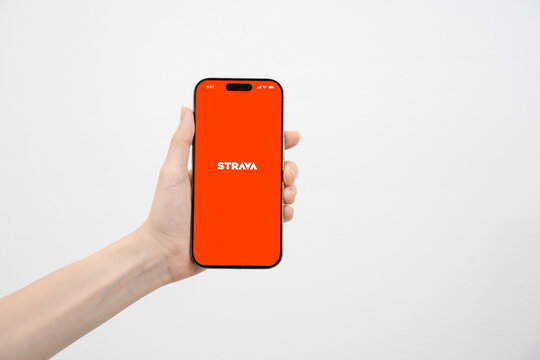 A person holding a mobile phone closeup, while using sport application Strava