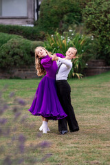 Elegant young boy and girl in ballroom dance attire performing outdoors. This juvenile dance couple captures grace, discipline, and youthful passion in a natural, outdoor setting. Ideal for themes rel