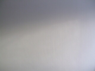 Minimalist background of plain grey wall with subtle gradient shadow from soft lighting