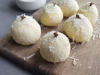 coconut kiss, typical Brazilian party sweets and cloves on a wooden background