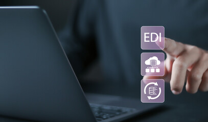 EDI Electronic Data Interchange concept. Platform for exchanging business documents between organizations. Person using laptop with EDI icons on virtual screen.