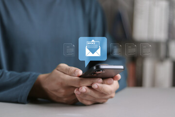 E-Invoice and online digital statements by email concept. Person using smartphone with email invoice document icon on virtual screen.