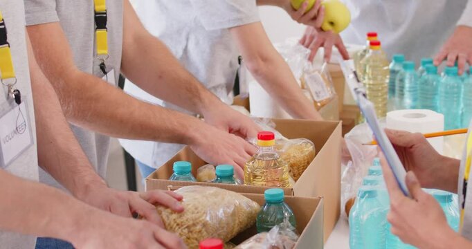 Volunteers working in food bank charity to help pack and sort food, collect meal donations in box set. Volunteering, giving unpaid help for people in need, helping others in community and support 