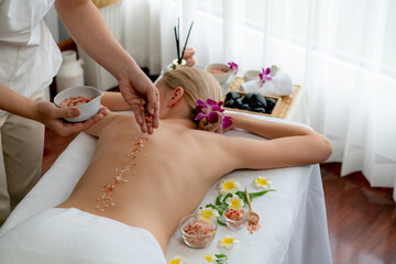 Woman customer having exfoliation treatment in luxury spa salon with warmth candle light ambient....