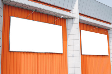 Two Blank banner or billboard mockups on the orange wall of a building. Street advertising on the...