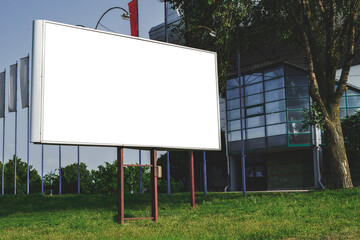 Billboard street advertising mockup. against the backdrop of a glass building in a city with green...