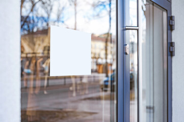 Blank white box signboard mockup on glass door.