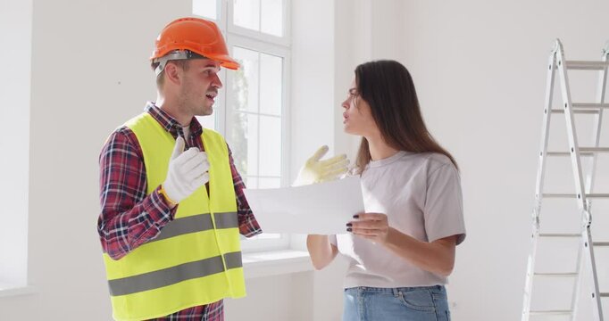 Young angry worried stressed emotional frustrated female house owner investor argues male worker over blueprint floor plan construction problem, wrong measurement size, low quality renovation material