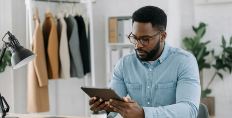 African adult male business professional using tablet in office setting