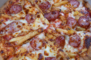 Close-Up of Rustic Pizza with Sausages, Extra Cheese, and Fries – A Comfort Food Delight