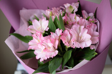 delicate bouquet with pink alstroemerias in wrapping, close-up