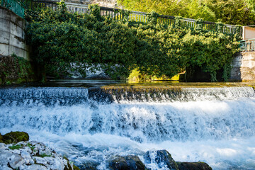 Spring mountain landscape with a bridge over a bubbling river cascade in Abkhazia, Georgia. Water...