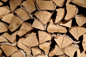 Selbstklebende Fototapeten Close-up image of a neatly stacked firewood pile, showcasing cut logs arranged for efficient storage. The wood's natural texture and pattern provide a rustic appearance. © Seluna