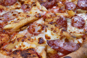 Close-up of Sausage Pizza with Extra Cheese and French Fries