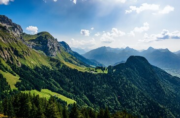 A dramatic view of the ridged mountain slope and cloudy sky during ascent to Talamarche, framed by trees