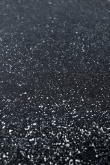 Close-up of textured road with white particles

