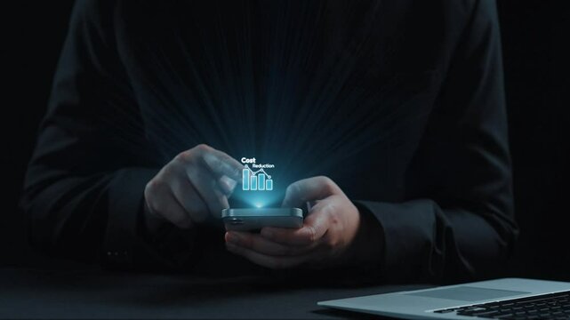 A person holding a smartphone displays virtual icons representing cost reduction and business analytics on a dark background, symbolizing financial strategies for growth. Qubit