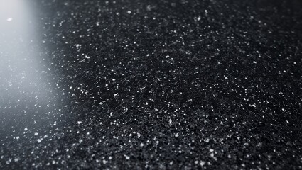 Obraz premium Close-up of polished black granite countertop with reflective mineral flecks and textured finish