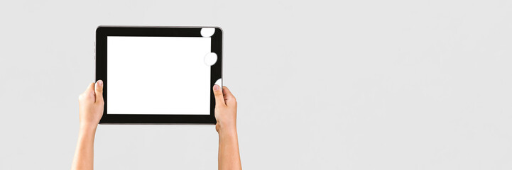 Long Banner, digital tablet mockup in a child's hand. The background is light gray. Close-up,