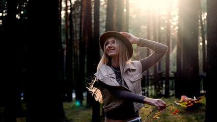 Hippie woman spinning around and enjoying life with a smile on her face outdoors in the forest....