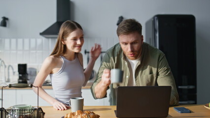 Hurrying husband kissing wife bringing coffee cups at home kitchen closeup. 