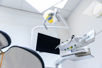 Modern Dental Clinic Equipment Featuring an Overhead Light and Chair in a Bright, Clean Environment...