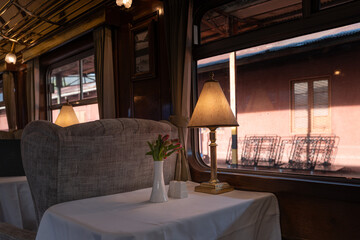 Elegant interior of the Titicaca Train on the scenic route from Cusco to Puno, featuring vintage decor and panoramic windows.