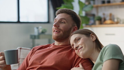 Fototapeta premium Romantic pair relaxing couch with coffee mugs closeup. Loving woman resting man