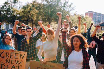 Young activists raising fists for green new deal and carbon footprint reduction