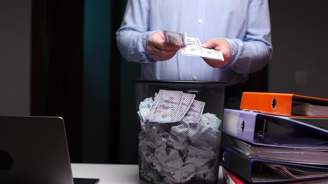 Man throwing paper bills in trash can. Man throwing money away