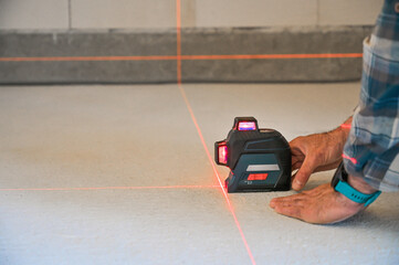 A person using a laser level tool on a smooth surface to ensure accurate measurements, showcasing...