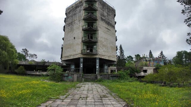 Crumbling concrete and overgrown vegetation enveloping the abandoned Hotel Aia, a former Soviet-era spa in Tskaltubo, Georgia, reflect years of neglect
