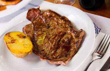 Beef steak with potatoes on a white plate