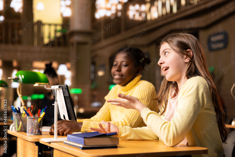 Poster girls participating in an online course at the library joining a live video webinar with their teach