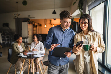 diverse young entrepreneurs use mobile phone together in modern office