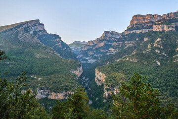 A landscape of the Cañon de Añisclo valley, with high rocky mountains, green forests. in Ordesa natural park, Huesca, Aragon, Spain